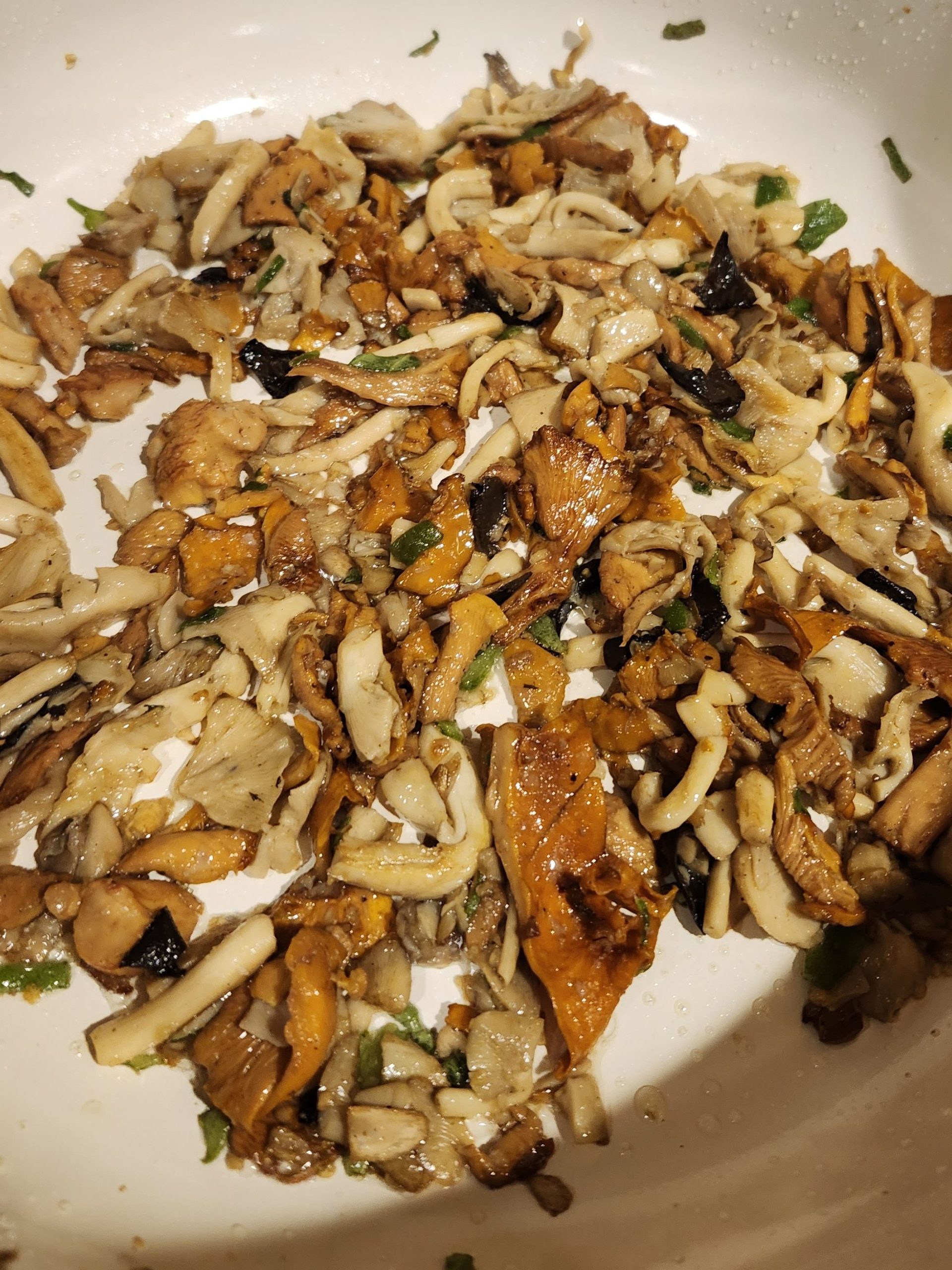 variety of gourmet mushrooms sauteing in pan